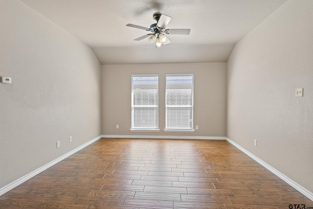 empty room with hardwood / wood-style floors, vaulted ceiling, and ceiling fan