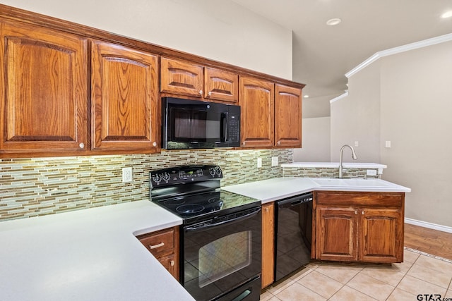 kitchen featuring decorative backsplash, black appliances, sink, light tile patterned floors, and ornamental molding