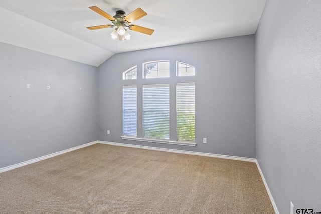 carpeted spare room featuring ceiling fan and lofted ceiling