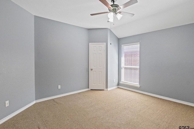 carpeted empty room featuring lofted ceiling and ceiling fan