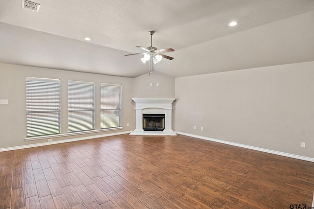 unfurnished living room featuring ceiling fan, vaulted ceiling, dark hardwood / wood-style floors, and a textured ceiling