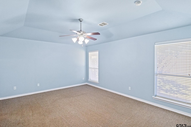 spare room with lofted ceiling, a raised ceiling, ceiling fan, and carpet floors