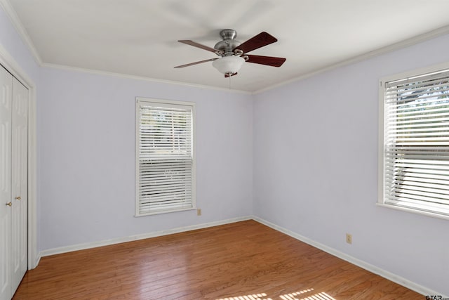 unfurnished room featuring a wealth of natural light, ceiling fan, light hardwood / wood-style flooring, and crown molding