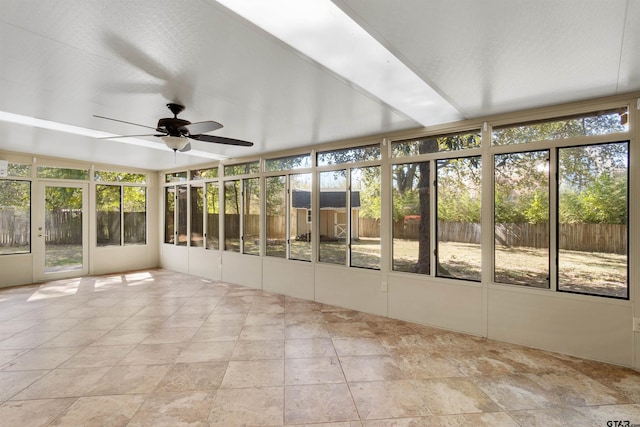 unfurnished sunroom with ceiling fan