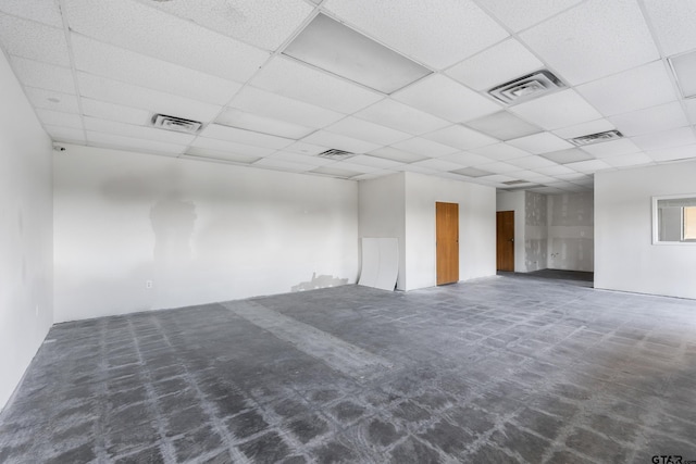 carpeted spare room with a drop ceiling