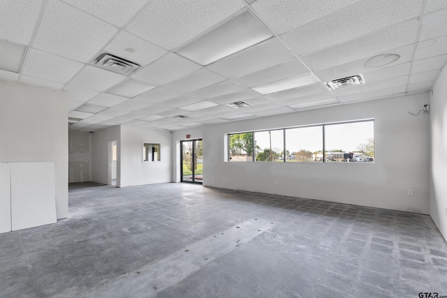 spare room featuring a drop ceiling and a wealth of natural light