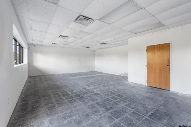 carpeted empty room featuring a paneled ceiling