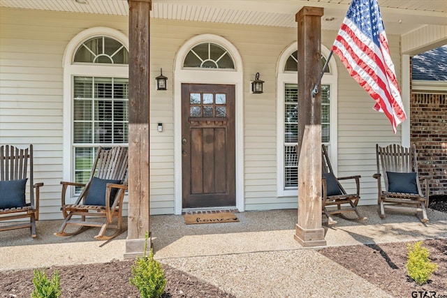 view of exterior entry featuring covered porch