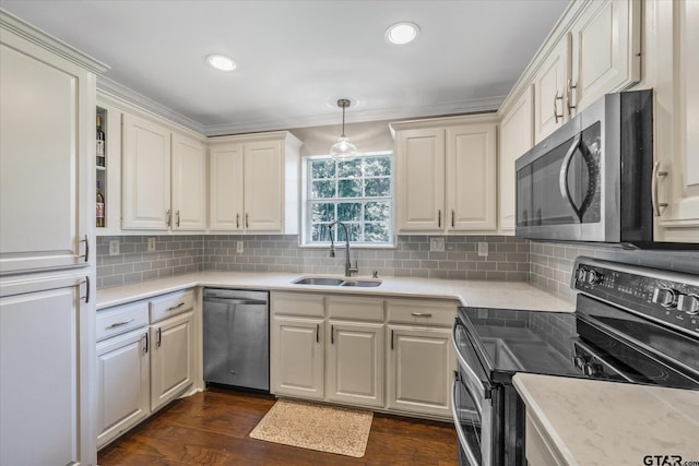 kitchen featuring appliances with stainless steel finishes, dark wood-type flooring, a sink, and tasteful backsplash