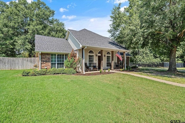 view of front of house with roof with shingles, fence, a front lawn, a porch, and brick siding