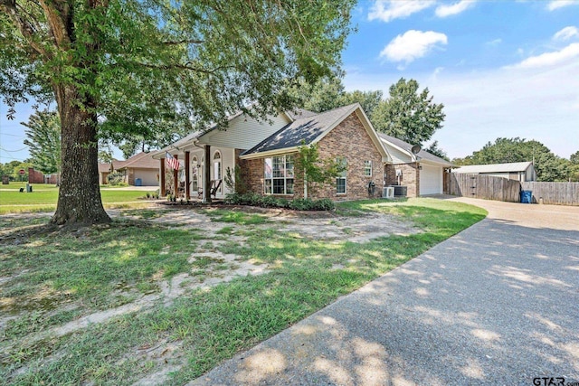 single story home with driveway, an attached garage, fence, a front lawn, and brick siding