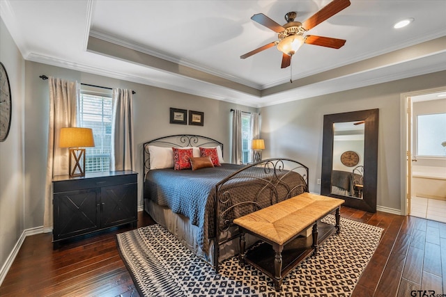 bedroom featuring a raised ceiling, baseboards, crown molding, and hardwood / wood-style floors