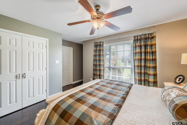 bedroom with dark wood-style flooring, a closet, a ceiling fan, and baseboards