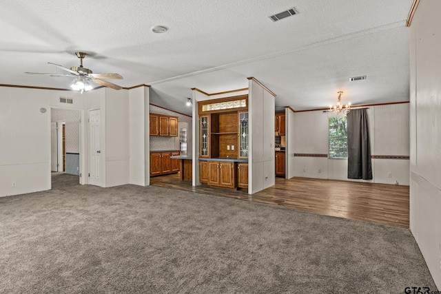 364 San Saba Ln, Mount Vernon, TX 75457 - unfurnished living room featuring dark carpet, visible vents, ceiling fan with notable chandelier, and a textured ceiling