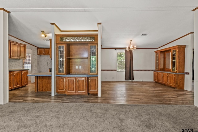 364 San Saba Ln, Mount Vernon, TX 75457 - kitchen with crown molding, brown cabinetry, plenty of natural light, and an inviting chandelier