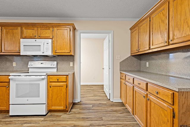 593 Briarwood Dr, Gladewater, TX 75647 - kitchen featuring white appliances, crown molding, light wood-style floors, tasteful backsplash, and light countertops