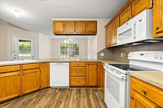 593 Briarwood Dr, Gladewater, TX 75647 - kitchen featuring white appliances, dark wood finished floors, a sink, plenty of natural light, and a textured ceiling