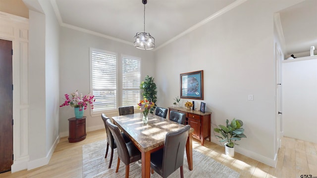 dining space featuring a notable chandelier, light hardwood / wood-style flooring, and ornamental molding