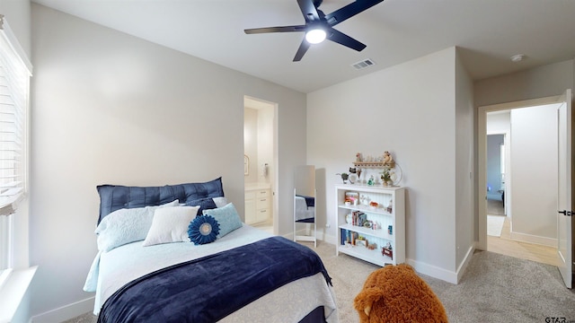 carpeted bedroom with ceiling fan and ensuite bath