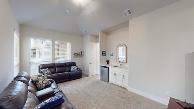 living room with light carpet, sink, and vaulted ceiling