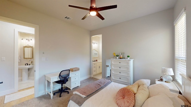 bedroom with ensuite bathroom, ceiling fan, and light hardwood / wood-style floors