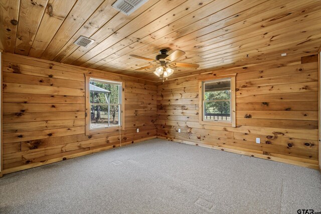 11698 Piper Ln, Frankston, TX 75763 - empty room with healthy amount of natural light, wooden ceiling, carpet, a ceiling fan, and wood walls