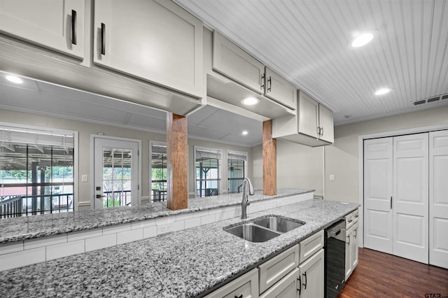 kitchen with dark wood-style flooring, light stone countertops, a sink, visible vents, and dishwashing machine