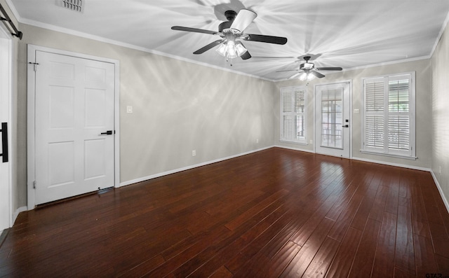 empty room with a barn door, hardwood / wood-style floors, a ceiling fan, baseboards, and visible vents