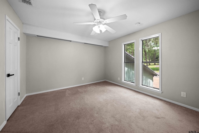 unfurnished room with carpet floors, a ceiling fan, baseboards, and visible vents