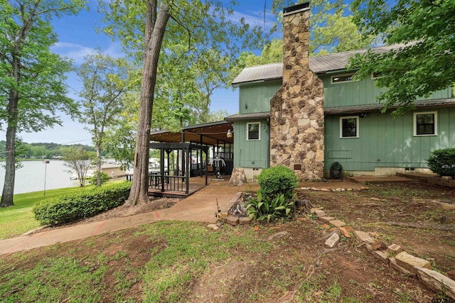 back of property with a patio area, fence, a chimney, and metal roof