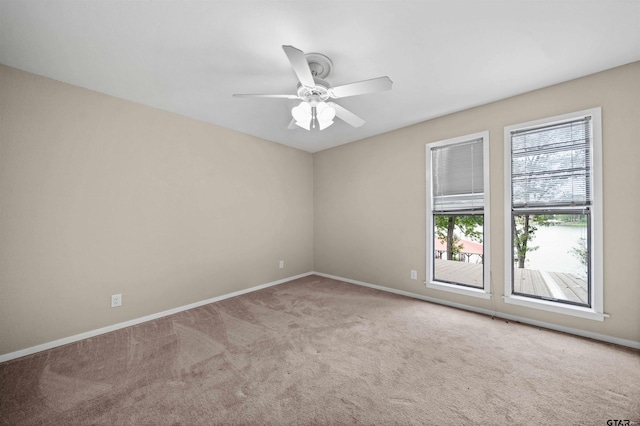 spare room featuring ceiling fan, baseboards, and carpet
