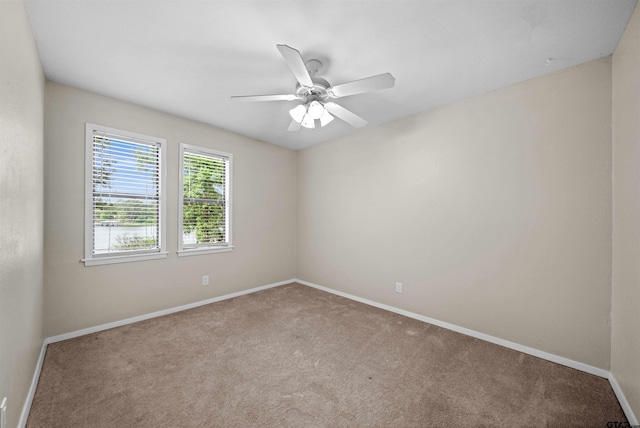 empty room featuring baseboards, a ceiling fan, and carpet