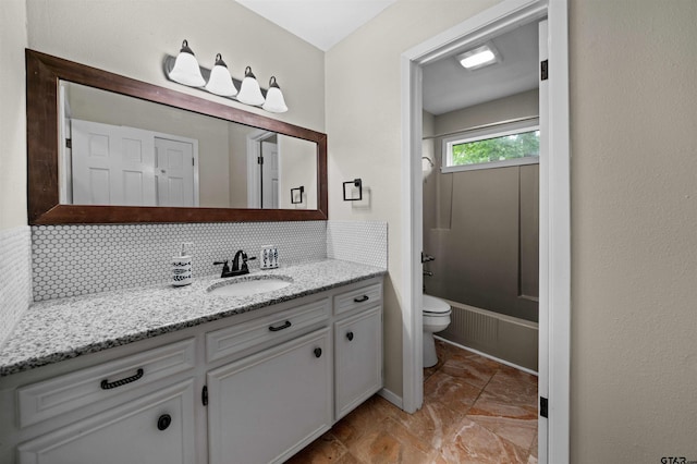 bathroom featuring vanity, backsplash, and toilet