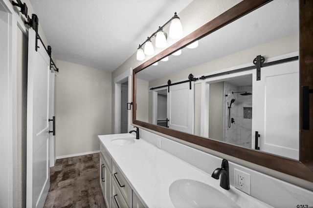 bathroom with double vanity, a sink, baseboards, and a shower stall