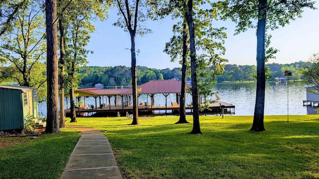 exterior space with a gazebo, a water view, a boat dock, and a yard