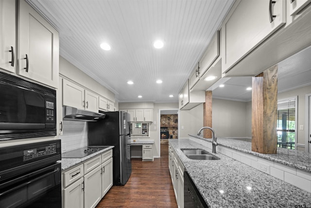 kitchen with crown molding, a sink, recessed lighting, under cabinet range hood, and black appliances