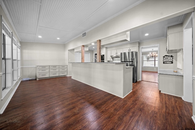 kitchen featuring crown molding, freestanding refrigerator, dark wood-type flooring, and white cabinets