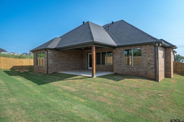 rear view of house featuring a patio and a yard