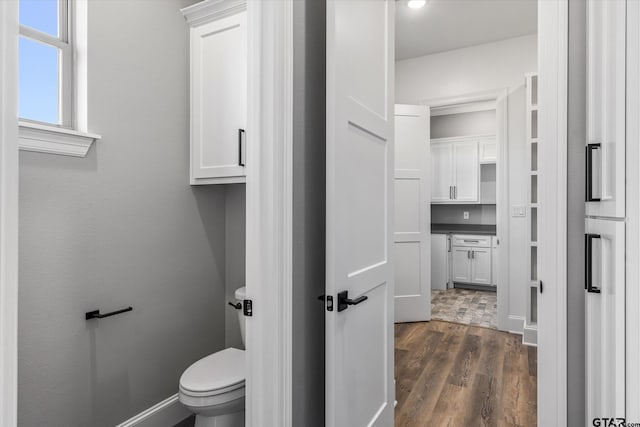 bathroom featuring wood-type flooring and toilet