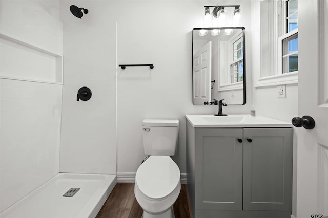 bathroom featuring walk in shower, vanity, wood-type flooring, and toilet