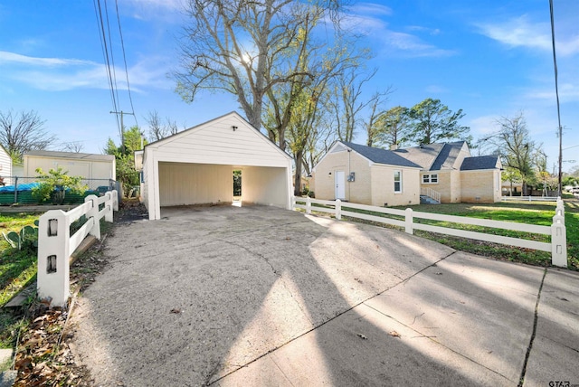 view of front of house featuring a carport, a garage, and an outbuilding