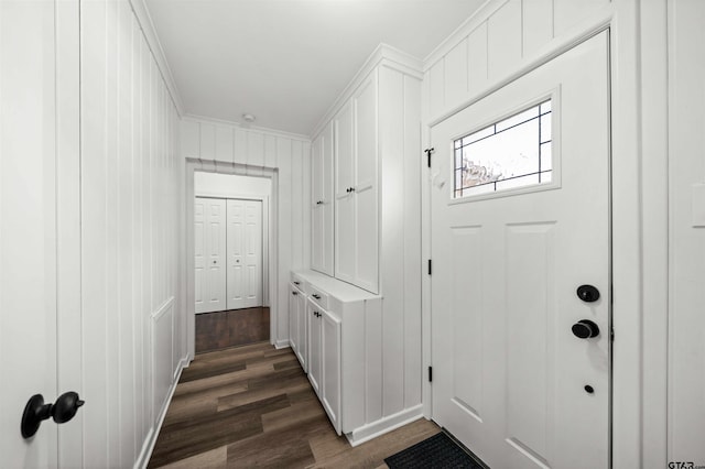 doorway with crown molding and dark wood-type flooring