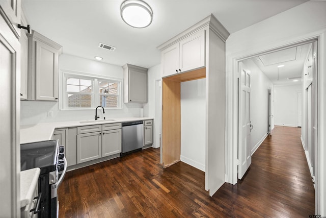 kitchen with dishwasher, sink, stove, gray cabinets, and decorative backsplash