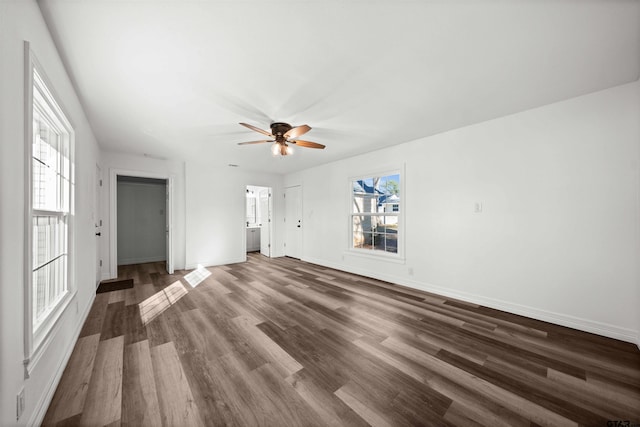 unfurnished living room with ceiling fan and dark wood-type flooring