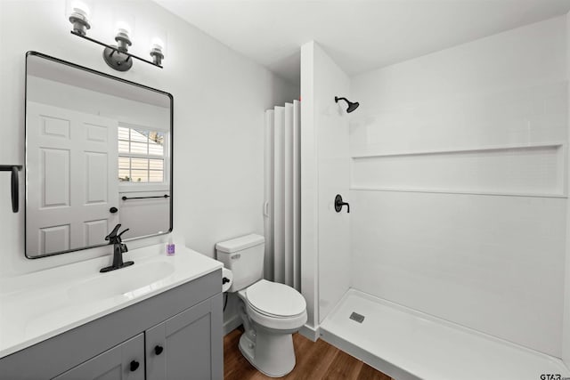 bathroom with toilet, hardwood / wood-style floors, vanity, and a shower with shower curtain