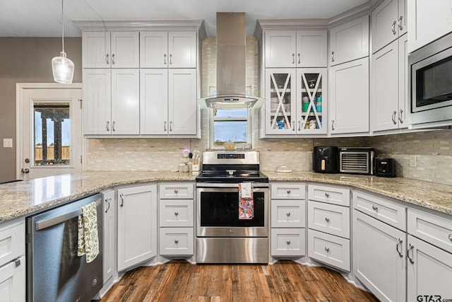 kitchen featuring tasteful backsplash, appliances with stainless steel finishes, dark wood-style floors, wall chimney range hood, and decorative light fixtures