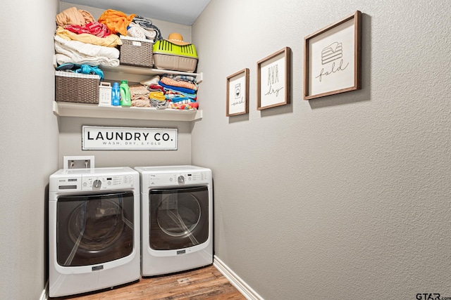 washroom with independent washer and dryer, wood finished floors, laundry area, and baseboards