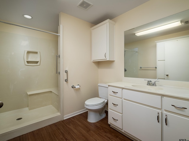 bathroom featuring walk in shower, wood-type flooring, vanity, and toilet