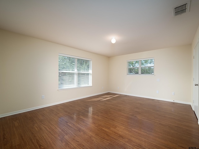 unfurnished room with dark hardwood / wood-style flooring and a healthy amount of sunlight