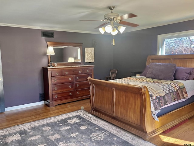 bedroom featuring crown molding, wood-type flooring, and ceiling fan